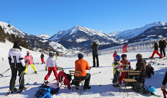 Gruppe von Personen, die an der Ankunft des Förderbandes des Weißen Tals eine Pause einlegen. Mit Blick auf den Pic Chaussy