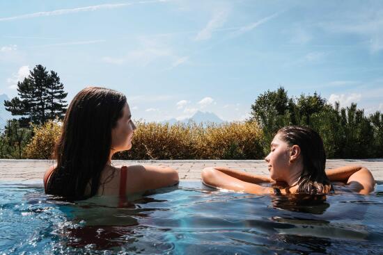 Deux jeunes femmes de dos se relaxant dans les Bains de Villars
