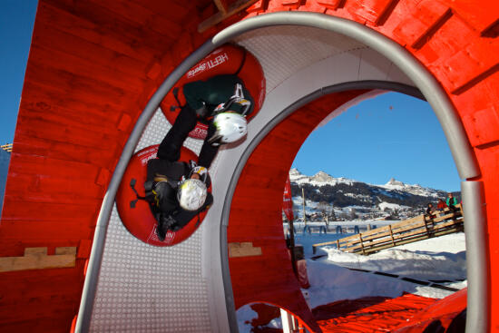 Deux personnes en bouée traversent un tunnel de glace au Tobogganing