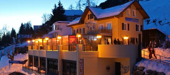Photo du restaurant le Bel Air en hiver au coucher du soleil avec terrasse couverte et éclairée